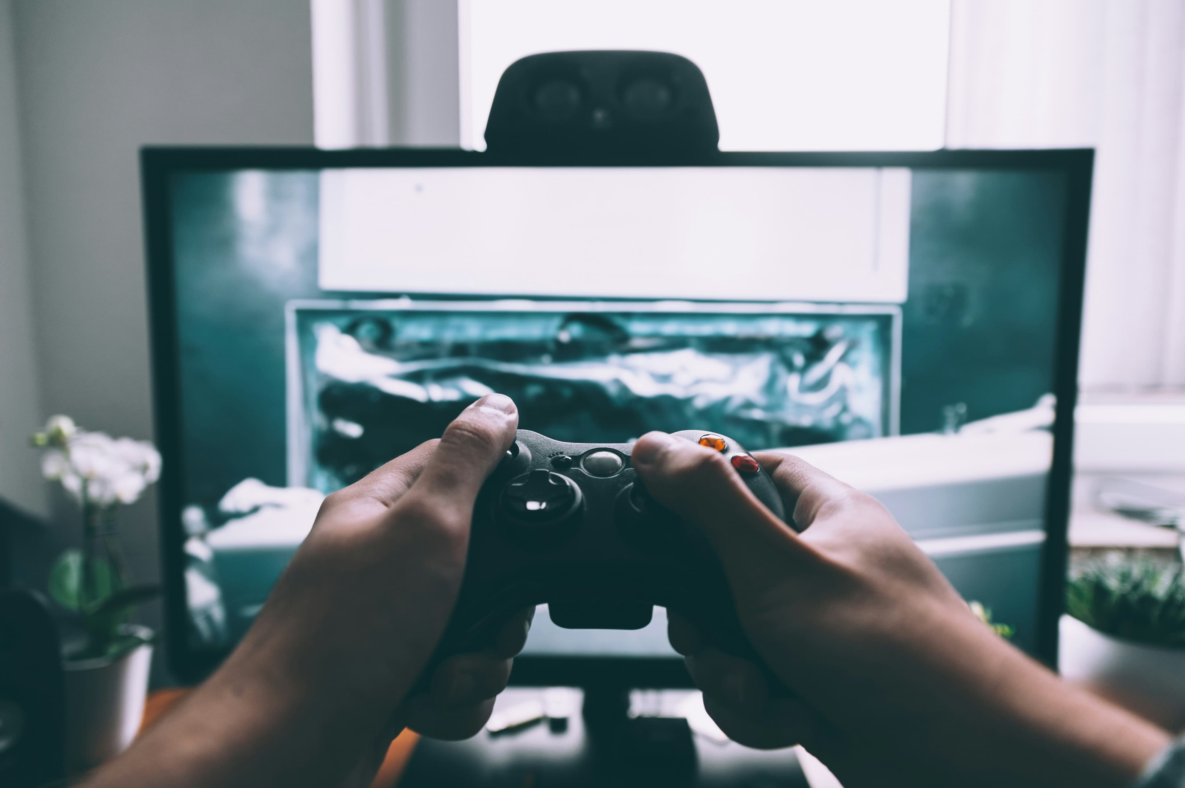 Человек с игровым контроллером перед телевизором