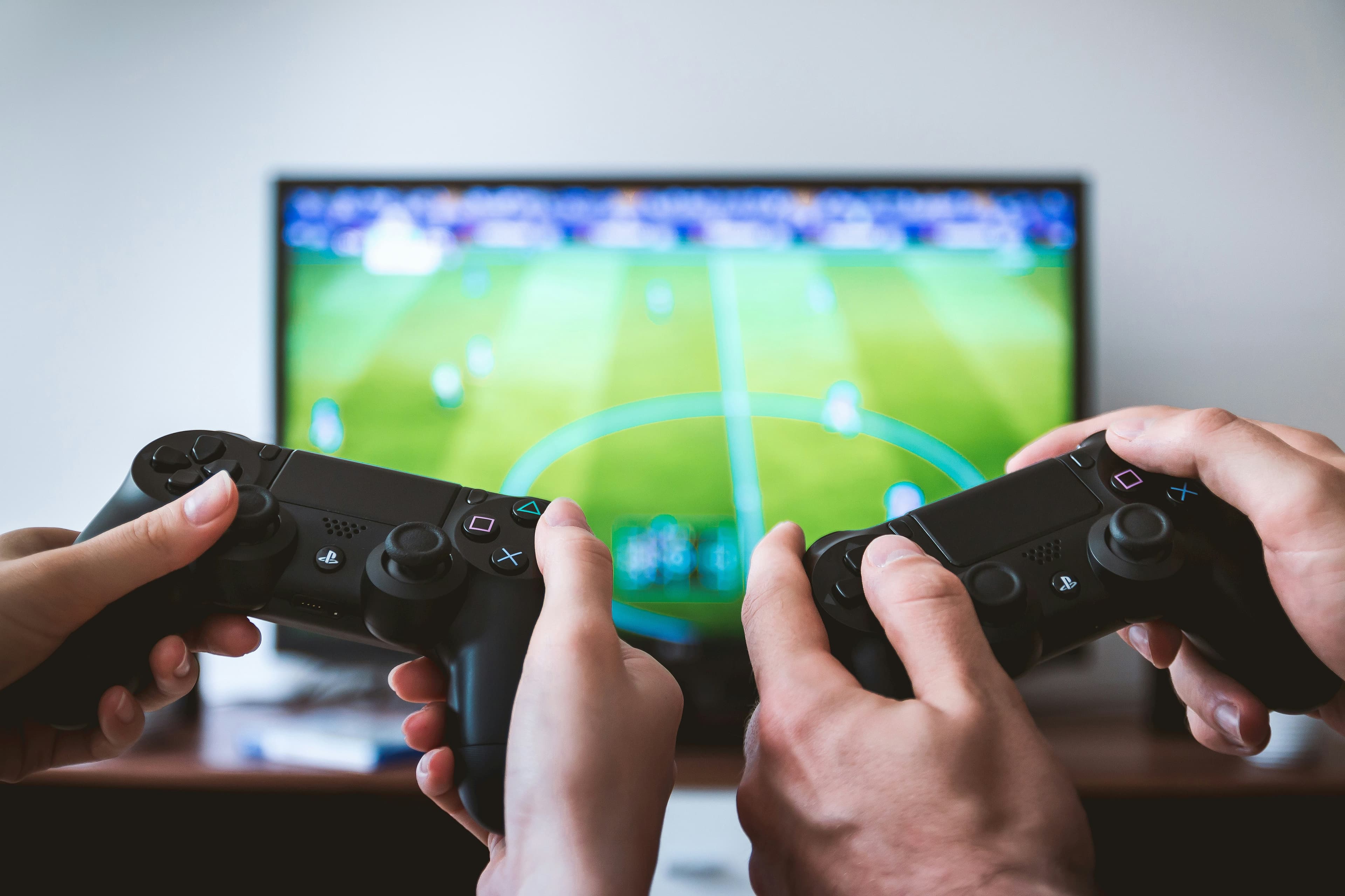 Двое играют в игровую консоль в гостиной