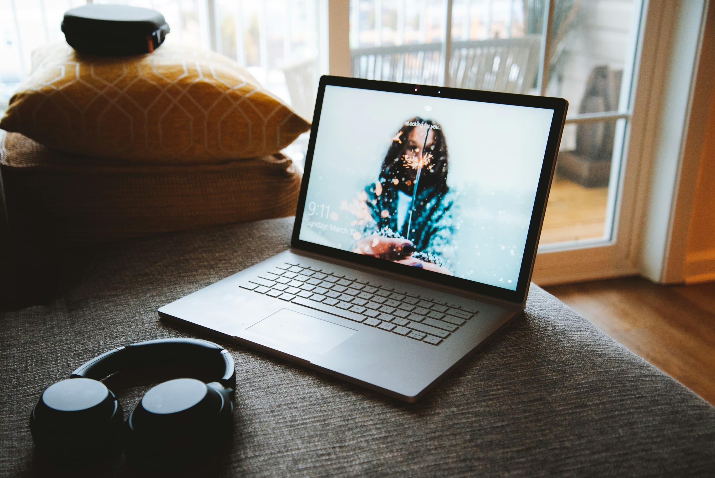 Ноутбук MacBook рядом с беспроводными наушниками — настройка для стриминга