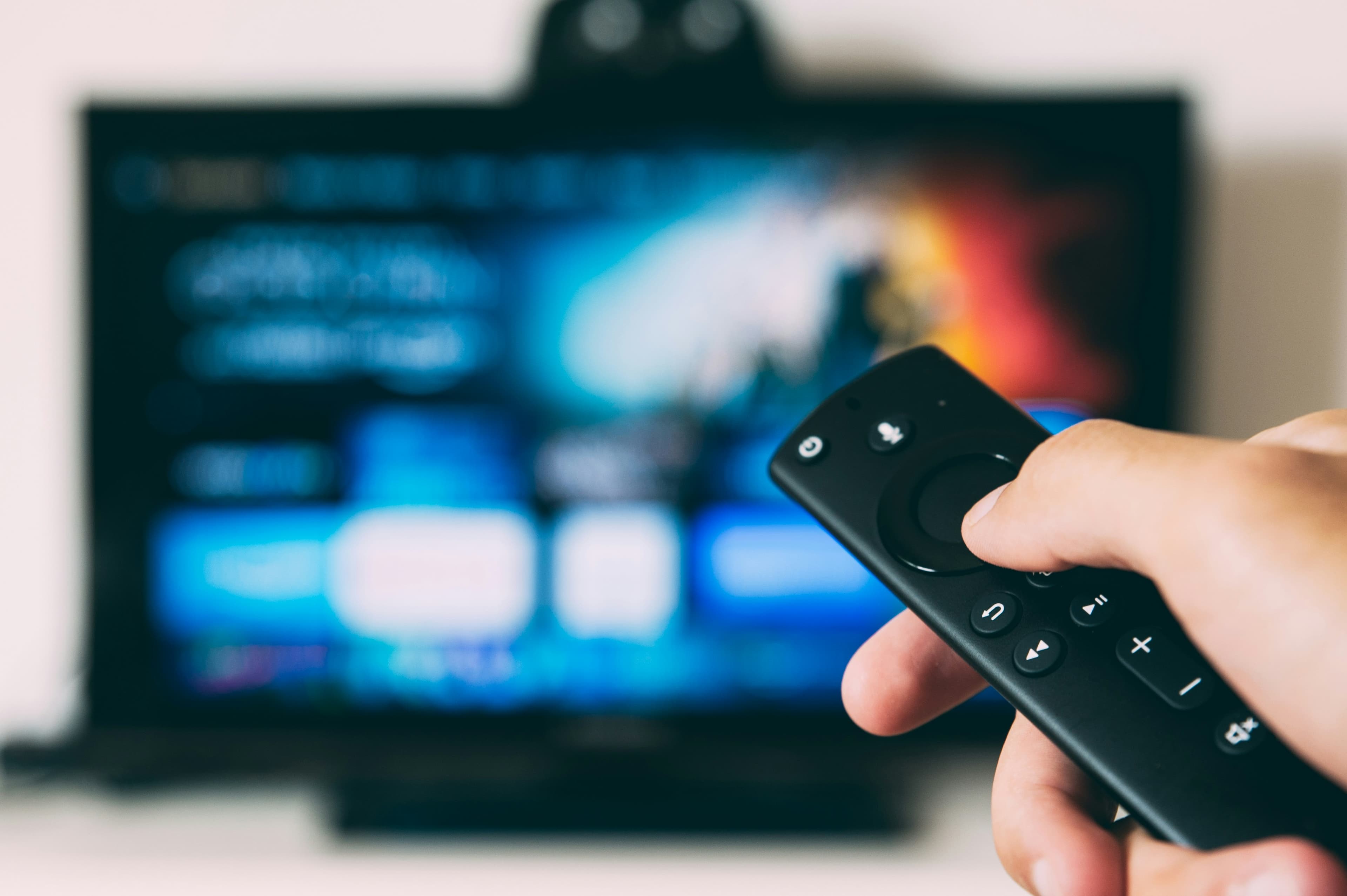 A remote control in front of a TV screen