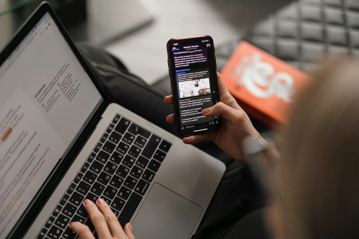 Смартфон и ноутбук рядом друг с другом на столе