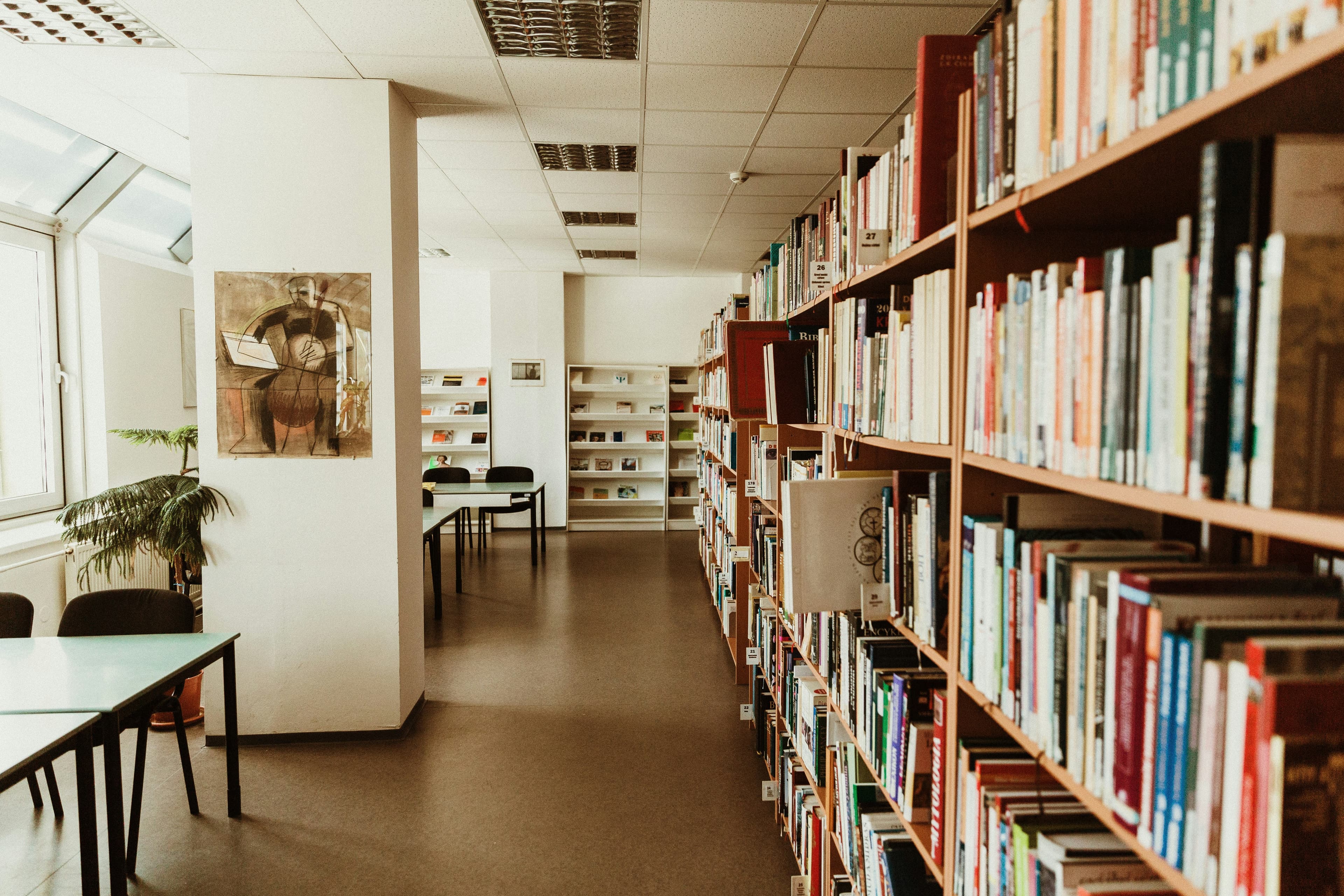 Книги и ноутбук на столе в библиотеке