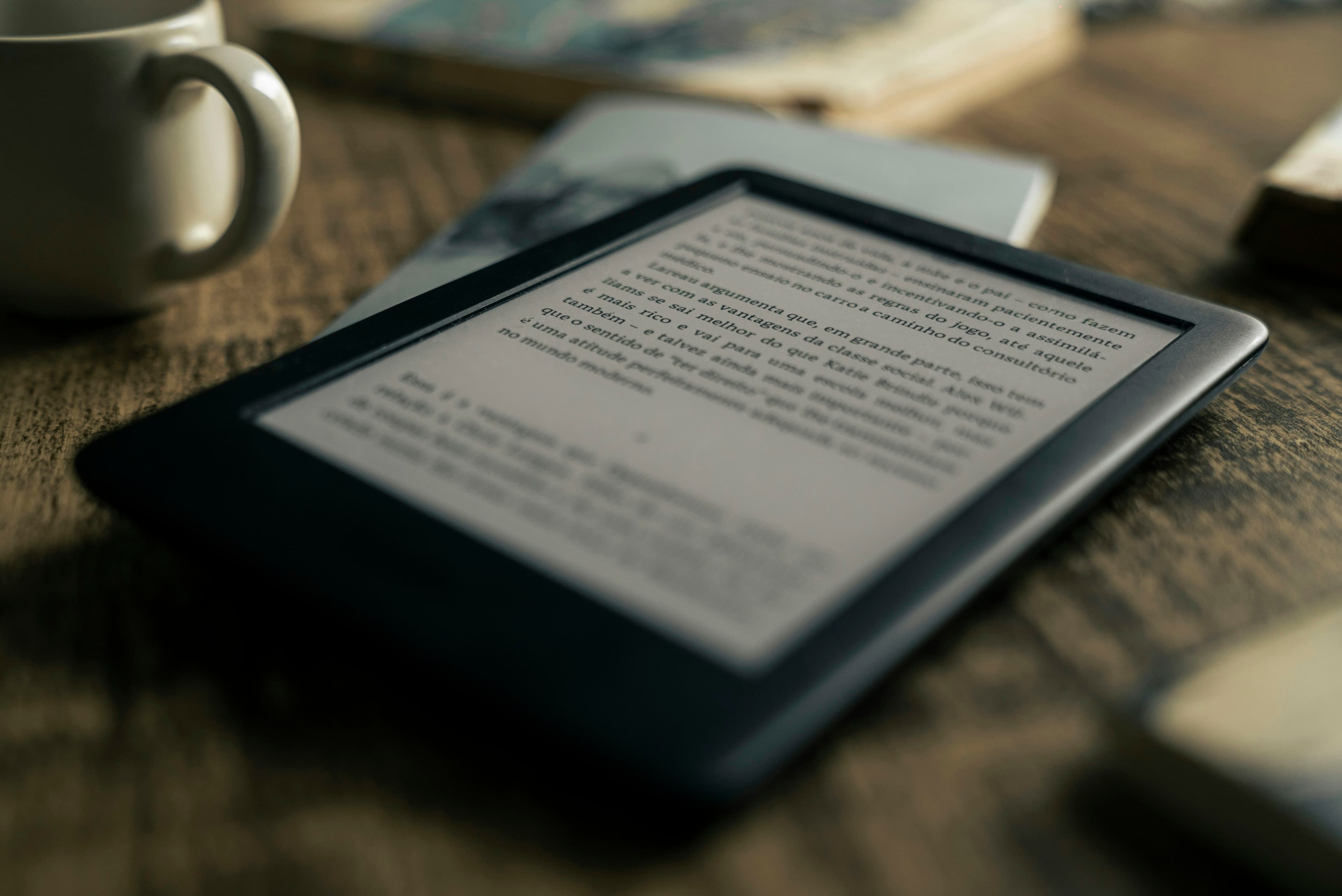 Планшет рядом со стопкой книг